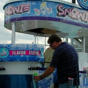 A man flavoriing his shaved ice at a Snowie Flavor Station
