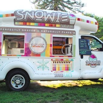 A white snowie bus parked on grass